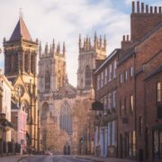 the historic old town of York along Museum St. looking towards York Minster Cathedral in Yorkshire, England, UK.